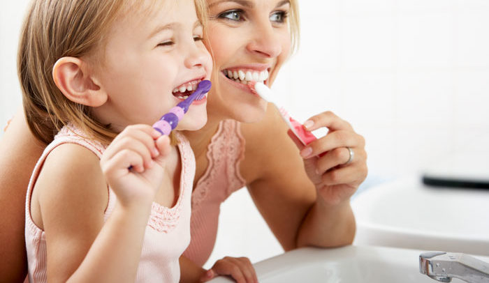 mother and child practicing good dental hygiene in bathroom