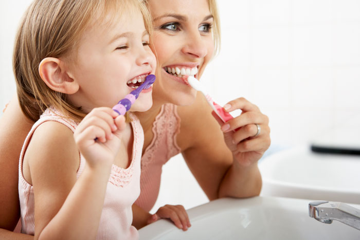 mother and child practicing good dental hygiene in bathroom