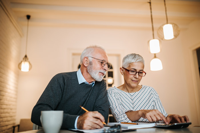 elderly couple weighing their long term care options at a dining room table